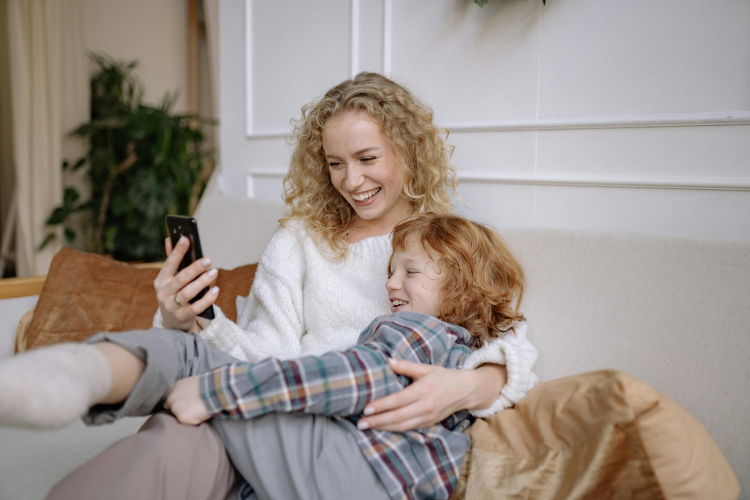 A photo of a mother and child looking at smartphone