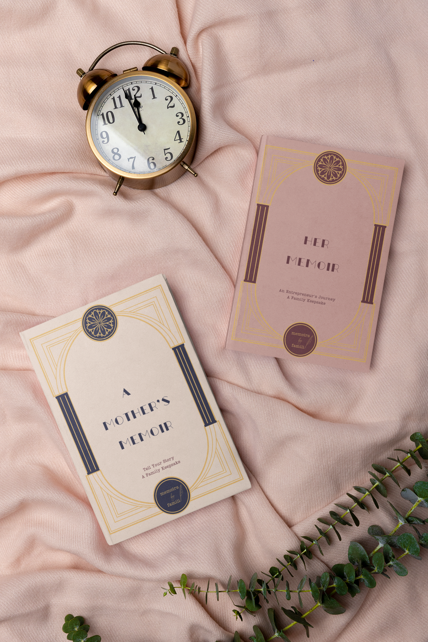 image of two books by Andrea Wills Bunce called A Mother's Memoir and Her Memoir, Entrepreneurs Edition and an alarm clock laying on a pink background