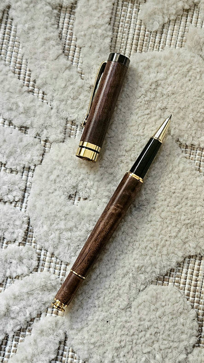 Luxury wooden walnut pen with gold accents on a textured surface